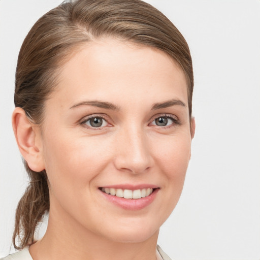 Joyful white young-adult female with medium  brown hair and grey eyes