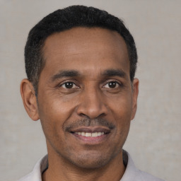 Joyful black young-adult male with short  black hair and brown eyes
