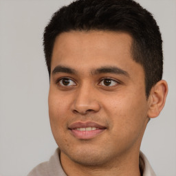 Joyful latino young-adult male with short  black hair and brown eyes