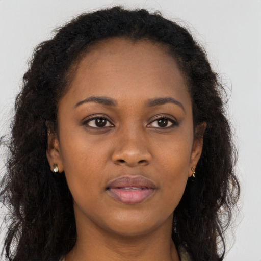 Joyful black young-adult female with long  brown hair and brown eyes