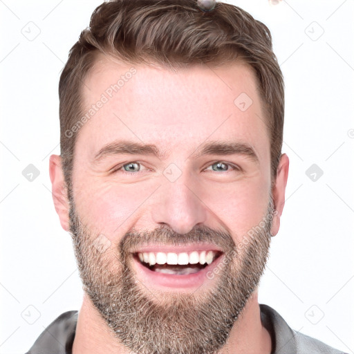 Joyful white young-adult male with short  brown hair and blue eyes