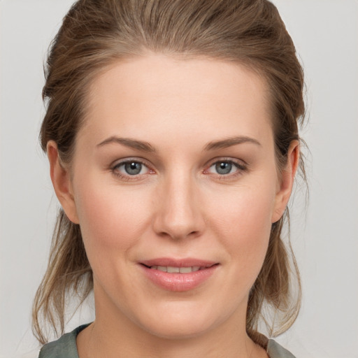 Joyful white young-adult female with medium  brown hair and grey eyes