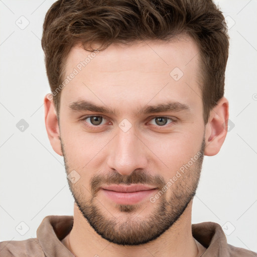 Joyful white young-adult male with short  brown hair and grey eyes