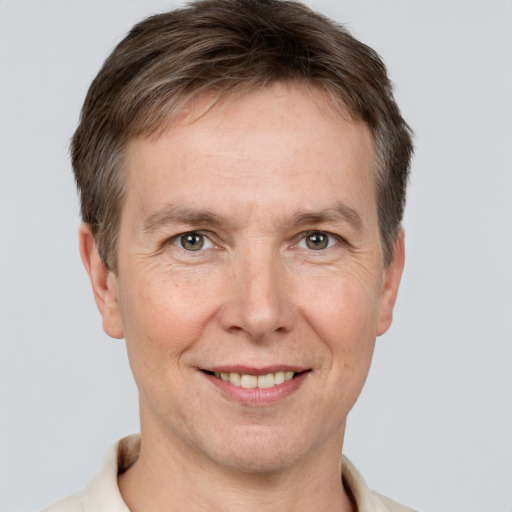 Joyful white adult male with short  brown hair and grey eyes