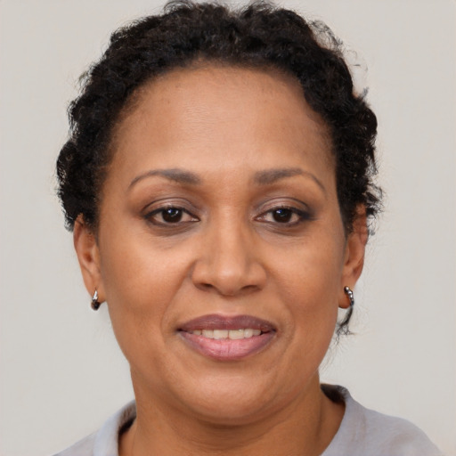 Joyful black adult female with short  brown hair and brown eyes