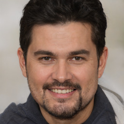 Joyful white adult male with short  brown hair and brown eyes