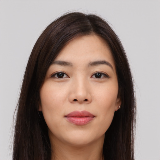 Joyful asian young-adult female with long  brown hair and brown eyes