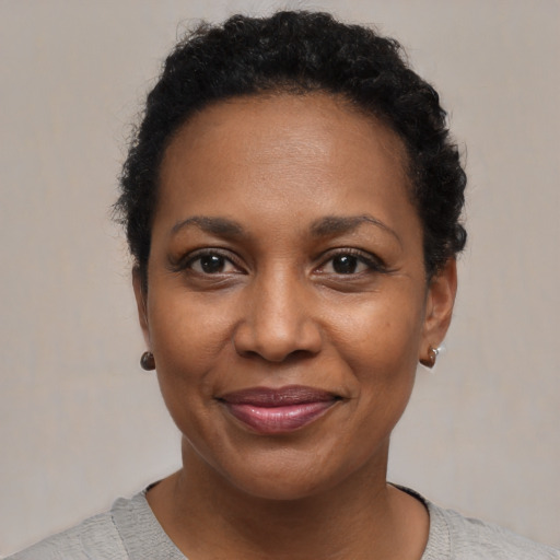 Joyful black young-adult female with short  black hair and brown eyes
