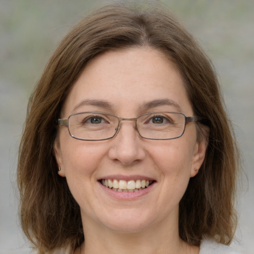 Joyful white adult female with medium  brown hair and green eyes