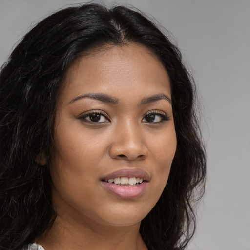 Joyful latino young-adult female with long  brown hair and brown eyes
