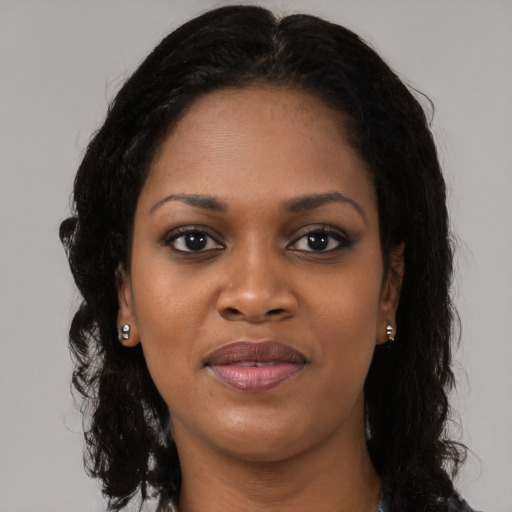 Joyful black young-adult female with long  brown hair and brown eyes