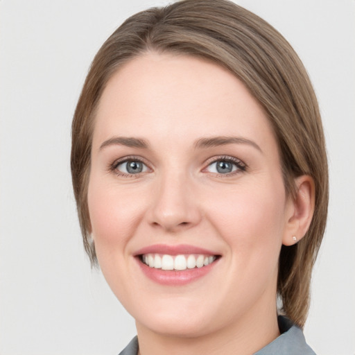 Joyful white young-adult female with medium  brown hair and green eyes