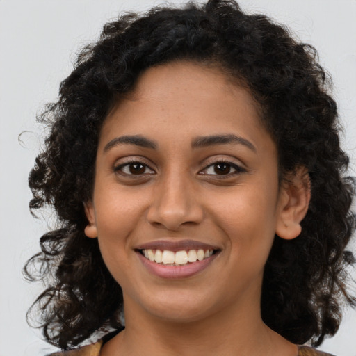 Joyful latino young-adult female with long  brown hair and brown eyes