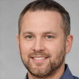 Joyful white adult male with short  brown hair and brown eyes