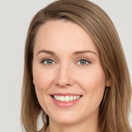 Joyful white young-adult female with long  brown hair and grey eyes