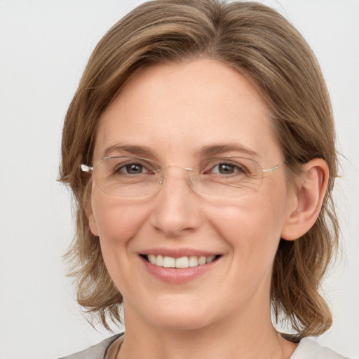 Joyful white adult female with medium  brown hair and grey eyes