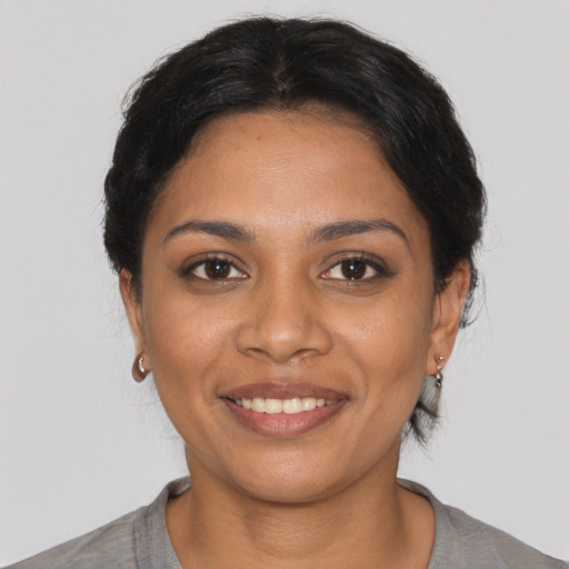 Joyful latino young-adult female with short  black hair and brown eyes
