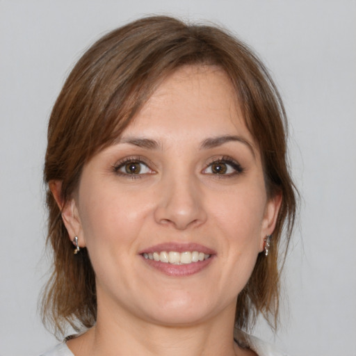 Joyful white young-adult female with medium  brown hair and grey eyes