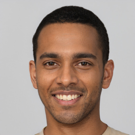 Joyful latino young-adult male with short  black hair and brown eyes