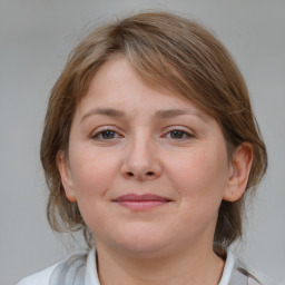 Joyful white young-adult female with medium  brown hair and grey eyes