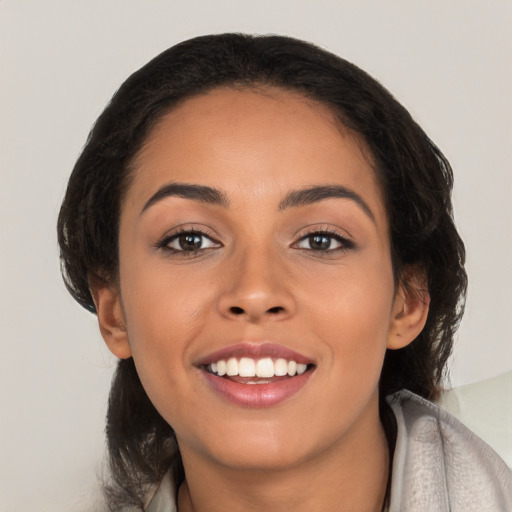 Joyful latino young-adult female with long  brown hair and brown eyes