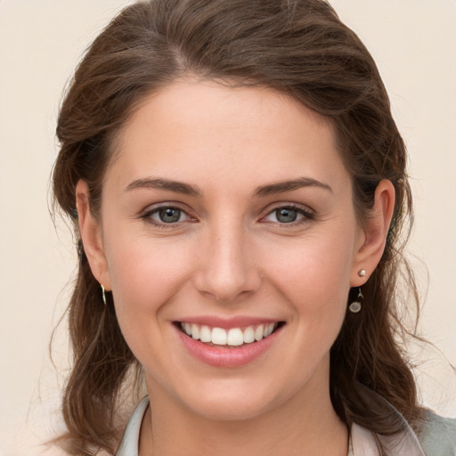 Joyful white young-adult female with medium  brown hair and grey eyes