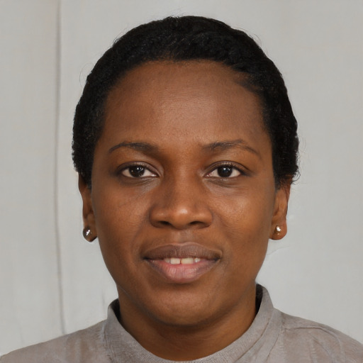 Joyful black young-adult female with short  black hair and brown eyes