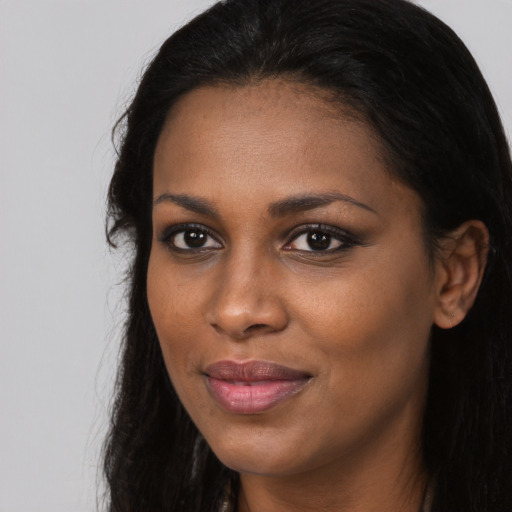 Joyful black young-adult female with long  black hair and brown eyes