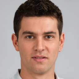 Joyful white young-adult male with short  brown hair and grey eyes