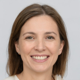 Joyful white adult female with medium  brown hair and grey eyes