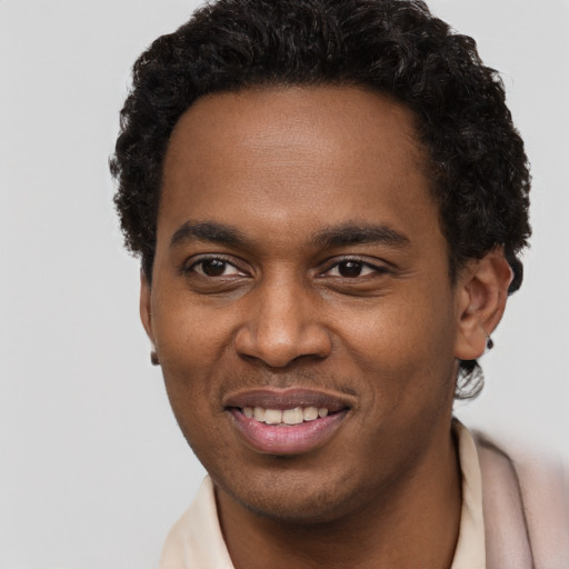 Joyful black young-adult male with short  brown hair and brown eyes