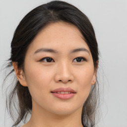 Joyful asian young-adult female with medium  brown hair and brown eyes