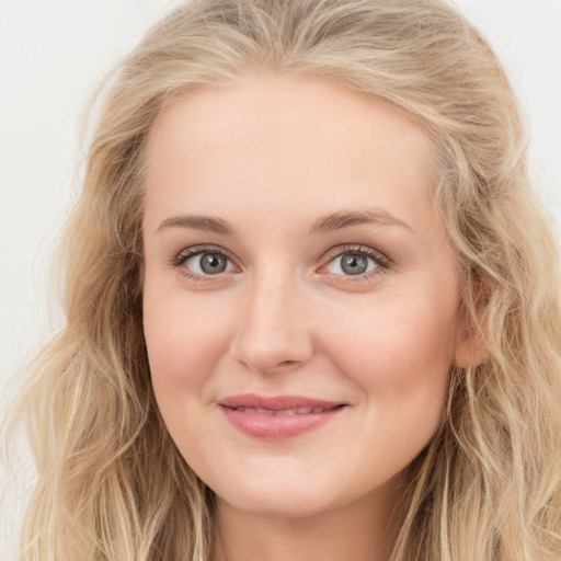 Joyful white young-adult female with long  brown hair and blue eyes