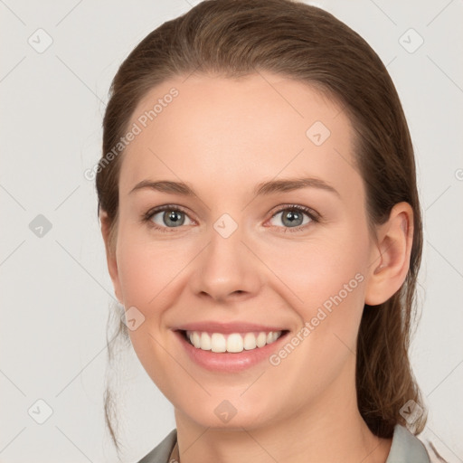 Joyful white young-adult female with medium  brown hair and grey eyes