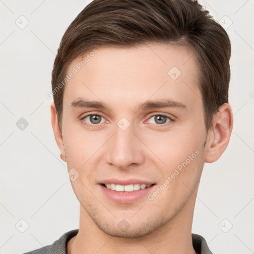 Joyful white young-adult male with short  brown hair and grey eyes