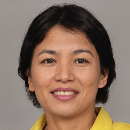 Joyful asian young-adult female with medium  brown hair and brown eyes