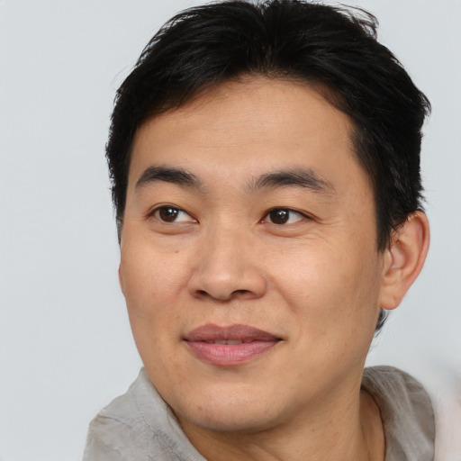 Joyful asian young-adult male with short  brown hair and brown eyes