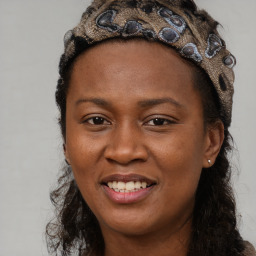 Joyful black adult female with long  brown hair and brown eyes