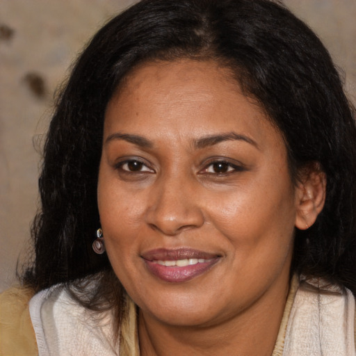 Joyful latino adult female with medium  brown hair and brown eyes