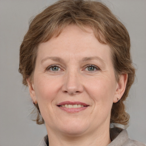 Joyful white adult female with medium  brown hair and grey eyes