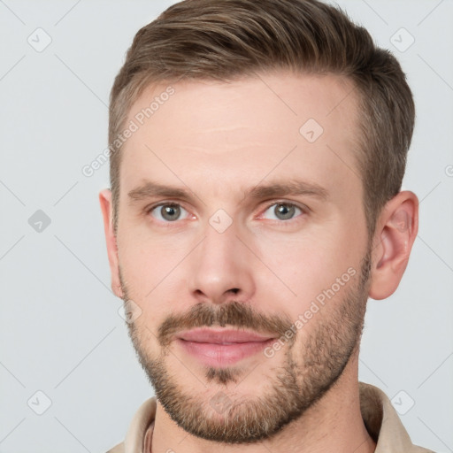 Joyful white young-adult male with short  brown hair and grey eyes