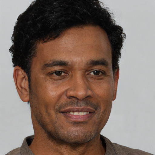 Joyful black adult male with short  black hair and brown eyes