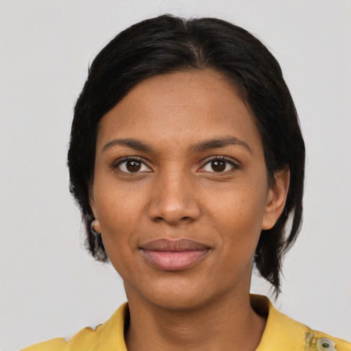 Joyful black young-adult female with short  black hair and brown eyes