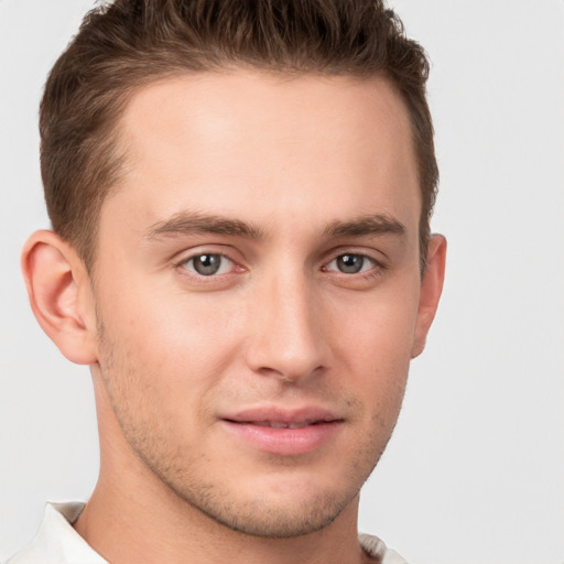 Joyful white young-adult male with short  brown hair and grey eyes