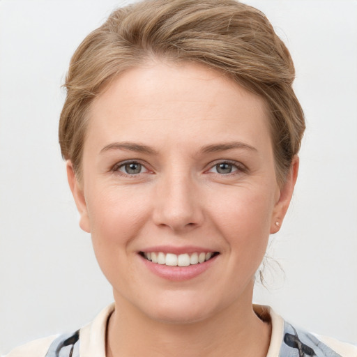 Joyful white young-adult female with short  brown hair and grey eyes