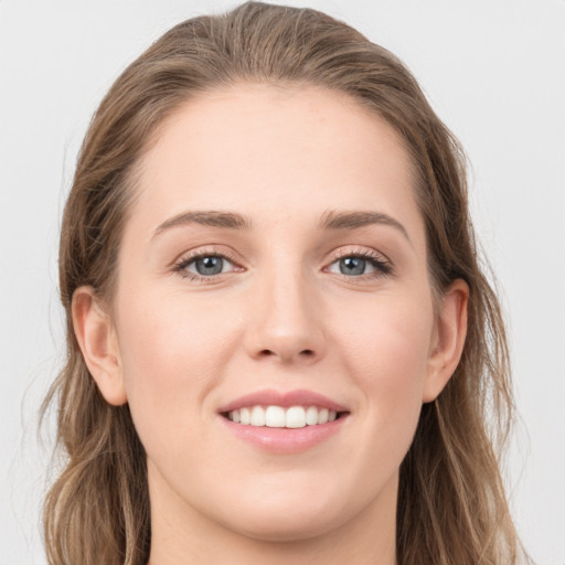 Joyful white young-adult female with long  brown hair and grey eyes