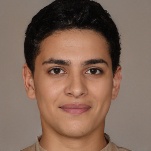 Joyful latino young-adult male with short  brown hair and brown eyes