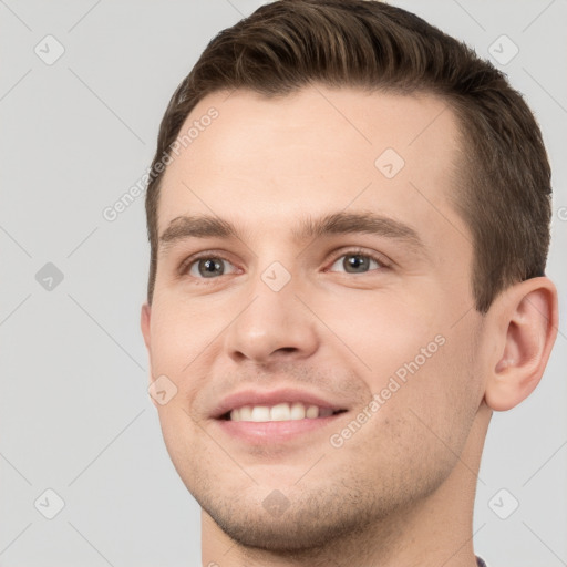 Joyful white young-adult male with short  brown hair and grey eyes