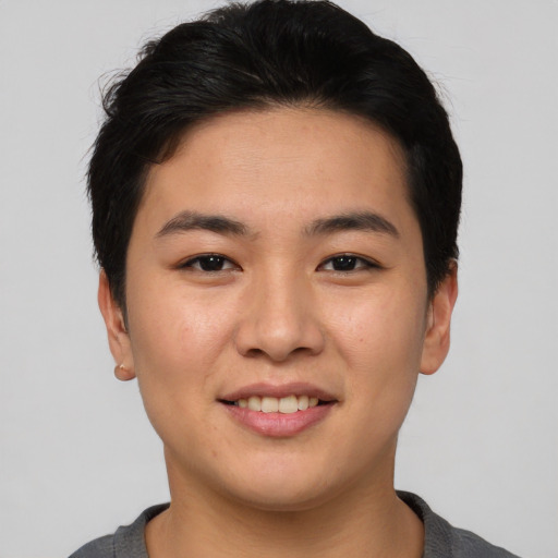 Joyful asian young-adult female with short  black hair and brown eyes