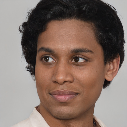 Joyful latino young-adult male with short  brown hair and brown eyes